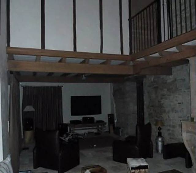 Séjour avec mezzanine et plafond à poutres en bois